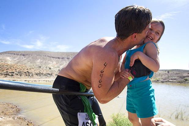 Daniel Green of Las Vegas stops to give a kiss to his daughter Ava, 5, during the Tough Mudder in Beatty, Nev. Sunday, April 14, 2013. Tough Mudder events are hardcore 10-12 mile obstacle courses designed to test all-around strength, stamina, mental grit, and camaraderie.