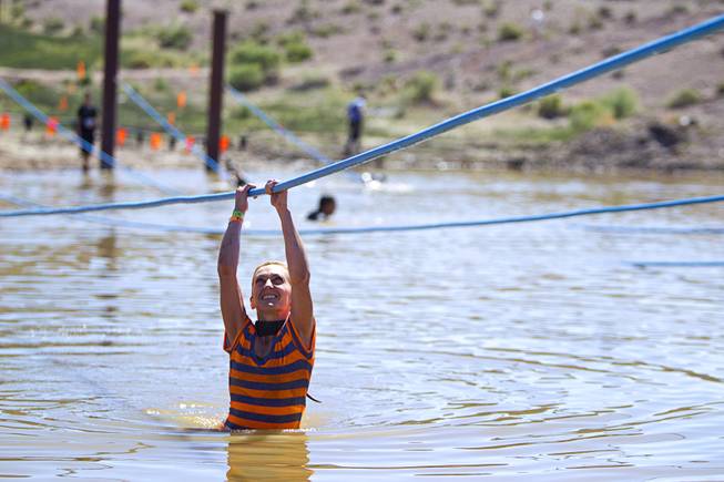 Mia Mijan of Las Vegas makes her way across an obstacle during the Tough Mudder in Beatty, Nev. Sunday, April 14, 2013. Tough Mudder events are hardcore 10-12 mile obstacle courses designed to test all-around strength, stamina, mental grit, and camaraderie.