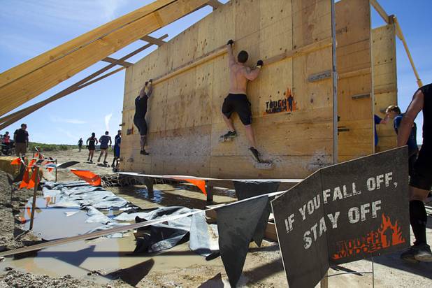 Competitors cross an obstacle during the Tough Mudder in Beatty, Nev. Sunday, April 14, 2013. Tough Mudder events are hardcore 10-12 mile obstacle courses designed to test all-around strength, stamina, mental grit, and camaraderie.