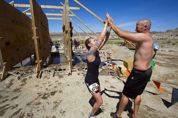 Mary Streets of Las Vegas celebrates with her husband Derek after crossing an obstacle during the Tough Mudder in Beatty, Nev. Sunday, April 14, 2013. Tough Mudder events are hardcore 10-12 mile obstacle courses designed to test all-around strength, stamina, mental grit, and camaraderie.