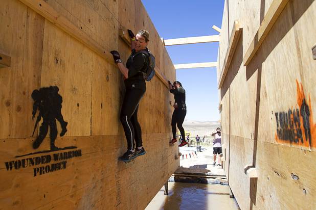 Competitors cross an obstacle during the Tough Mudder in Beatty, Nev. Sunday, April 14, 2013. Tough Mudder events are hardcore 10-12 mile obstacle courses designed to test all-around strength, stamina, mental grit, and camaraderie.