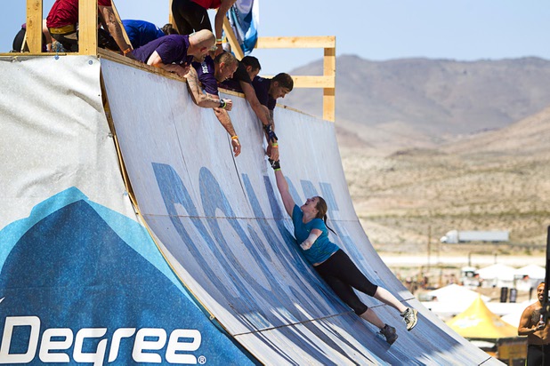 A one-armed woman gets a hand up at the "Everest" obstacle during the Tough Mudder in Beatty, Nev. Sunday, April 14, 2013. Tough Mudder events are hardcore 10-12 mile obstacle courses designed to test all-around strength, stamina, mental grit, and camaraderie.