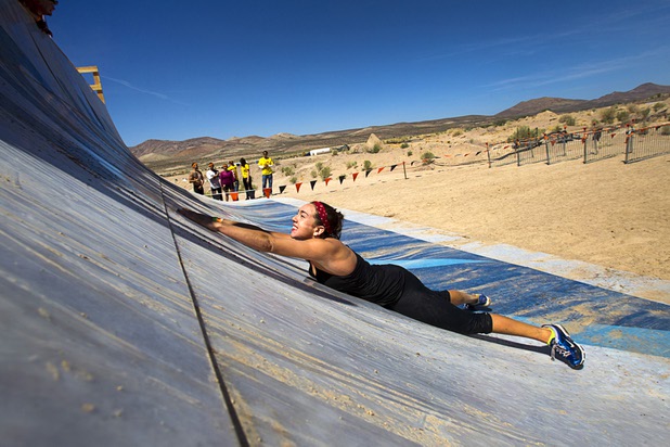 A woman slides back down a ramp after failing to make it up "Everest" on her first try during the Tough Mudder in Beatty, Nev. Sunday, April 14, 2013. Tough Mudder events are hardcore 10-12 mile obstacle courses designed to test all-around strength, stamina, mental grit, and camaraderie.