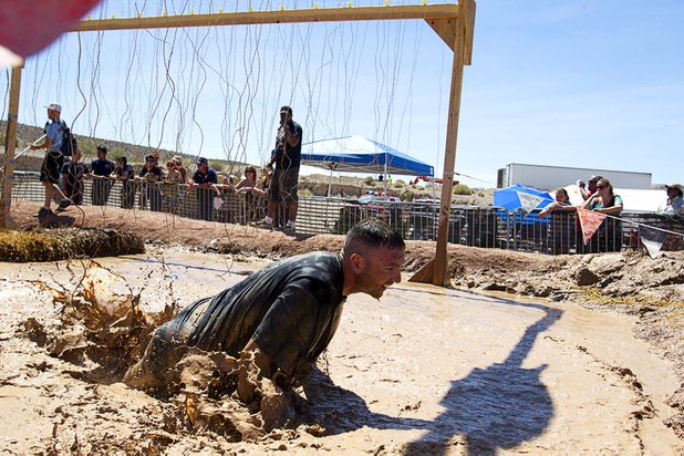 A man falls after being shocked by live wires in the "Electroshock Therapy" obstacle during the Tough Mudder in Beatty, Nev. Sunday, April 14, 2013. Tough Mudder events are hardcore 10-12 mile obstacle courses designed to test all-around strength, stamina, mental grit, and camaraderie.