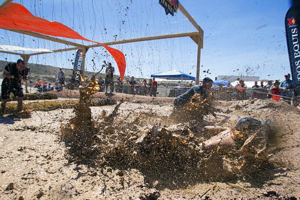A man falls after being shocked by live wires in the "Electroshock Therapy" obstacle during the Tough Mudder in Beatty, Nev. Sunday, April 14, 2013. Tough Mudder events are hardcore 10-12 mile obstacle courses designed to test all-around strength, stamina, mental grit, and camaraderie.