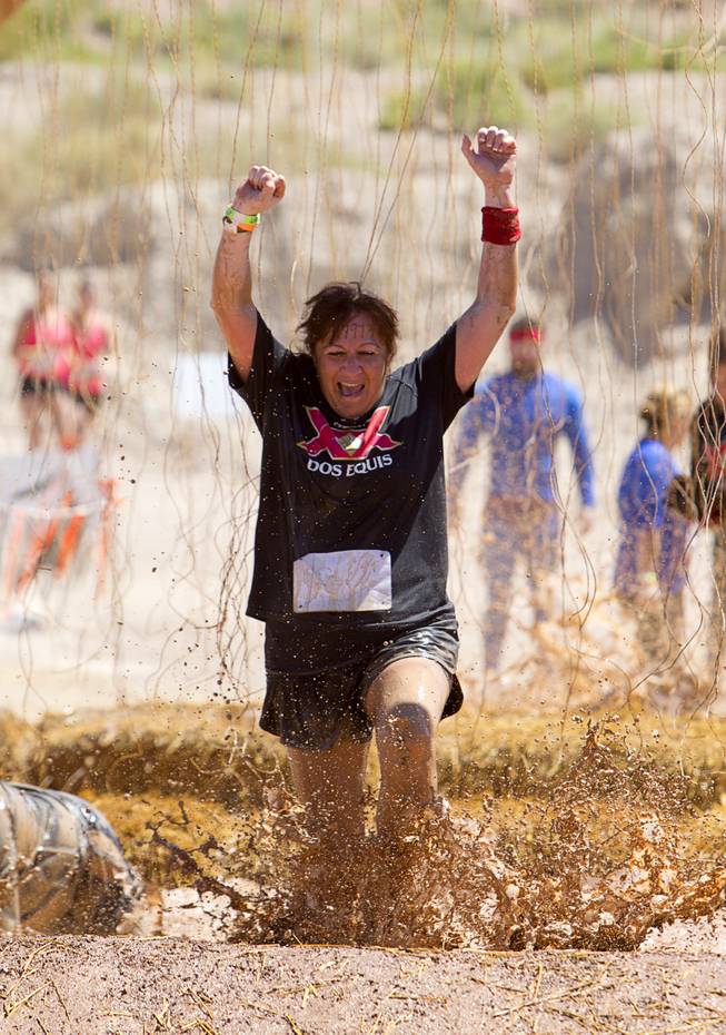 Gabrielle Cummings of Las Vegas celebrates as she makes it through the "Electroshock Therapy" obstacle during the Tough Mudder in Beatty, Nev. Sunday, April 14, 2013. Tough Mudder events are hardcore 10-12 mile obstacle courses designed to test all-around strength, stamina, mental grit, and camaraderie.