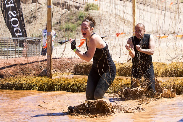 A couple make their way though live wires in the "Electroshock Therapy" obstacle during the Tough Mudder in Beatty, Nev. Sunday, April 14, 2013. Tough Mudder events are hardcore 10-12 mile obstacle courses designed to test all-around strength, stamina, mental grit, and camaraderie.