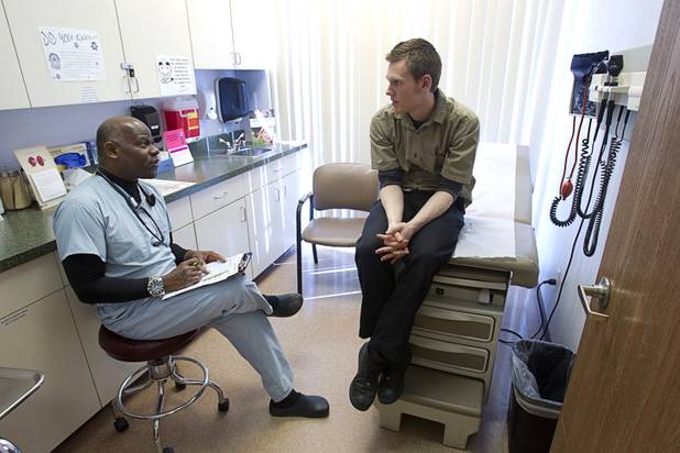 Hibbert Alfredo, certified physician assistant, talks with patient Jeremy Schlueter, at the Advanced Urgent Care clinic, 9975 S. Eastern Ave., Monday, April 15, 2013.