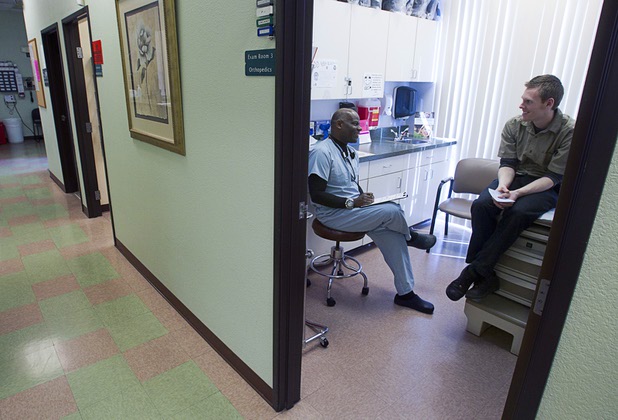 Hibbert Alfredo, certified physician assistant, talks with patient Jeremy Schlueter, at the Advanced Urgent Care clinic, 9975 S. Eastern Ave., Monday, April 15, 2013.