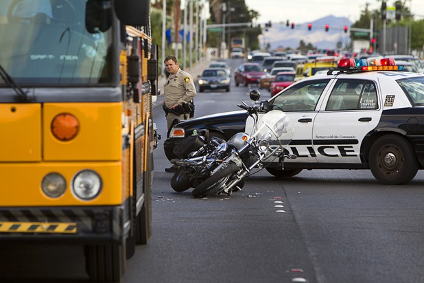 A Metro Police office stands by the scene of a motorcycle and school bus accident in the northbound lane of Eastern Avenue near Valley High School  Tuesday, April 16, 2013. The driver of the motorcycle appeared to have a broken leg, an officer said. There was a student on the bus but the student was not injured, he said. 
