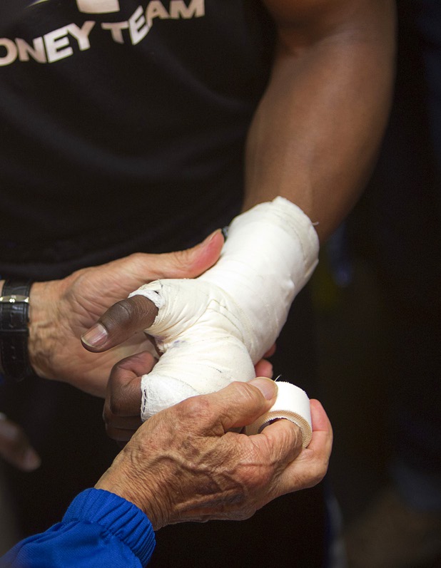 Undefeated welterweight boxer Floyd Mayweather Jr. has his hand wrapped by cutman Rafael Garcia before a work out at the Mayweather Boxing Club Wednesday, April 17, 2013. Mayweather will defend his WBC welterweight title against Robert Guerrero at the MGM Grand Garden Arena on May 4.