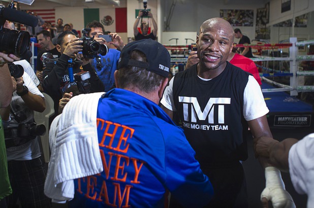 Members of his camp assist boxer Floyd Mayweather Jr. during a workout at the Mayweather Boxing Club Wednesday, April 17, 2013. Mayweather will defend his WBC welterweight title against Robert Guerrero at the MGM Grand Garden Arena on May 4.