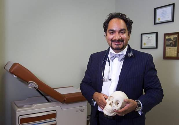 Dr. Samir Qamar poses with "Socrates," a skull used for teaching in medical school, at the MedLion office, 851 S. Rampart Blvd., Thursday, April 18, 2013. MedLion is a physician group membership plan. For $59 per month, patients get access to a primary care physician. There is no insurance involved.