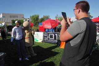 Kenny Keys jokes around with Mojave Max, the mascot for the Clark County Desert Conservation Program, while Aleks Vekic takes their photo during GreenFest at UNLV Saturday, April 20, 2013.