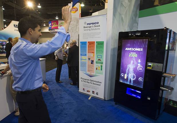 Steve Orlando of Phoenix plays a game on a vending machine equipped with XBox Kinect technology at a Pepsico booth during the NAMA (National Automatic Merchandising Association) One Show at the Sands Expo Center Wednesday, April 25, 2013. The NAMA One Show convention serves the vending, coffee and food service industries.