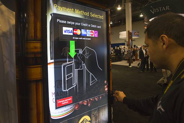 A man makes a credit card purchase of Marley Coffee during the NAMA (National Automatic Merchandising Association) One Show at the Sands Expo Center Wednesday, April 25, 2013. The NAMA One Show convention serves the vending, coffee and food service industries.