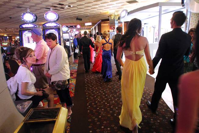 Gamblers watch as a group of Green Valley High School students walk through the Rio on their way to the Penn and Teller show on their prom night Saturday, April 27, 2013.