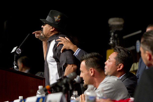 Oscar De La Hoya, right, president of Golden Boy Promotions, tries to calm Ruben Guerrero, father of boxer Robert Guerrero, as Ruben Guerrero calls Floyd Mayweather Jr. a "woman-beater" during a news conference at the MGM MGM Grand Wednesday, May 1, 2013.