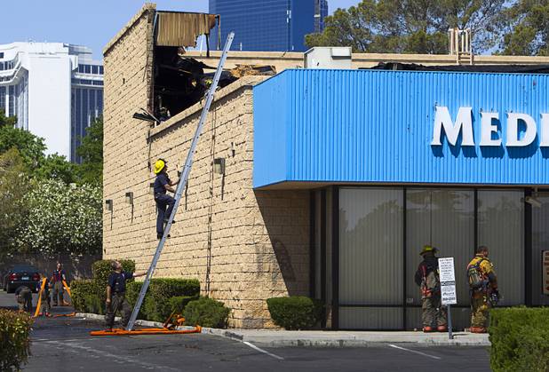 A firefighter descends a ladder after a fire at a medical building at Maryland Parkway near Vegas Valley Drive Wednesday,  May 1, 2013.