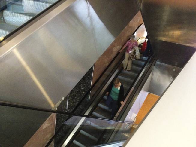Two women are seen walking down the escalator at the Regional Justice Center due to an afternoon power outage Thursday, May 2, 2013.