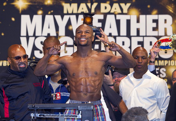 Undefeated WBC welterweight champion Floyd Mayweather Jr. poses on the scale during an official weigh-in at the MGM Grand Garden Arena Friday, May 3, 2013. Mayweather will defend his title against Robert Guerrero at the arena on Saturday.