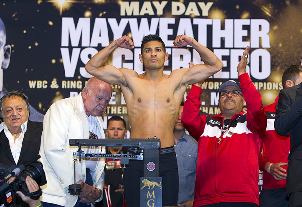 Featherweight boxer Abner Mares of Mexico flexes on the scale during an official weigh-in at the MGM Grand Garden Arena Friday, May 3, 2013. Mares will WBC featherweight champion Daniel Ponce De Leon, also of Mexico, for the title at the arena on Saturday.