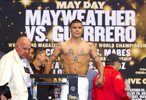 WBC featherweight champion Daniel Ponce De Leon of Mexico poses on the scale during an official weigh-in at the MGM Grand Garden Arena Friday, May 3, 2013. De Leon will defend his title against Abner Mares, also of Mexico,  at the arena on Saturday.
