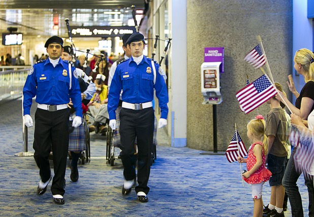 Members of the TSA Honor Guard and bagpipers with the Desert Skye Pipe Band lead a procession of World War II veterans as the veterans return from the first Las Vegas Honor Flight at McCarran International Airport Sunday, May 5, 2013. About 35 Southern Nevada veterans visited Baltimore and memorials in Washington D.C.