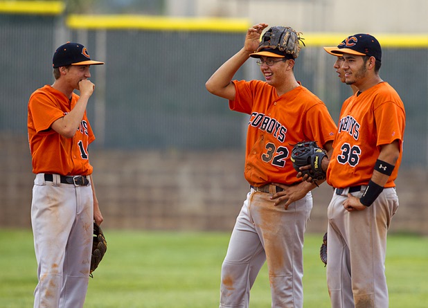 Chaparral Cowboys shortstop Tommy Crone, center, wears his glove on his head during a pitching change in Boulder City Tuesday, May 7, 2013.
