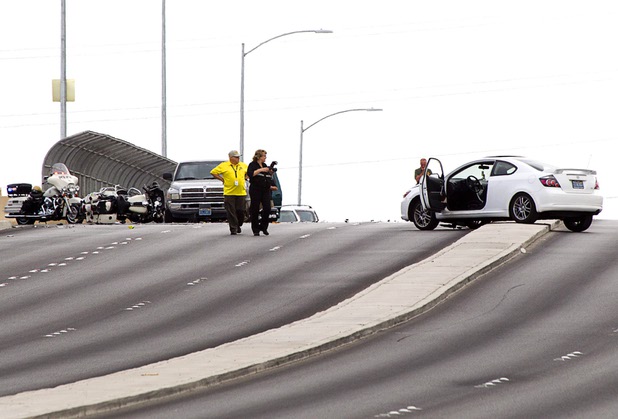 Officials investigate an accident between a car and a Metro Police motorcycle officer on the Durango Drive overpass over the Summerlin Parkway Wednesday, May 8, 2013. 
