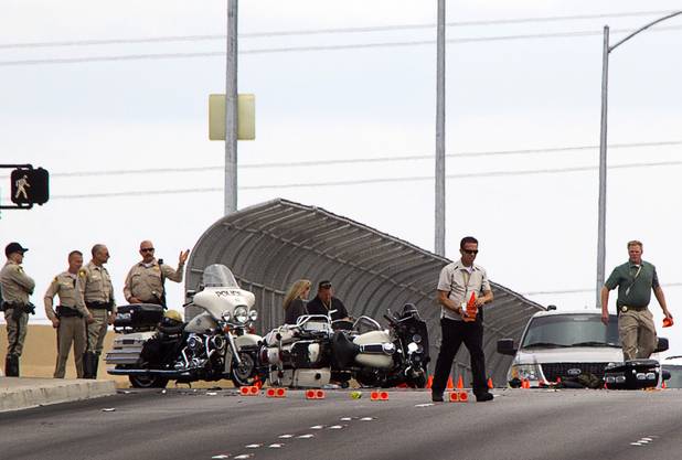 Officials place evidence cones as they investigate an accident between a car and a Metro Police motorcycle officer on the Durango Drive overpass over the Summerlin Parkway Wednesday, May 8, 2013.