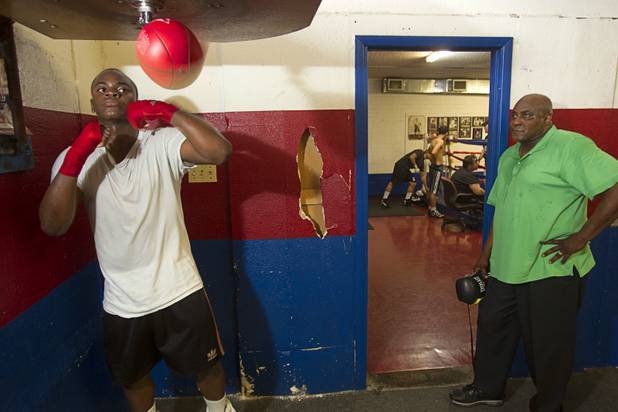 Mike McCallum Jr., a Silverado High School student, hits a speed bag as father looks on at Johnny Tocco's Boxing Gym Thursday, May 9, 2013.  Mike McCallum Sr., known as the "Body Snatcher" for his fierce body punching, won world titles in three weight divisions.