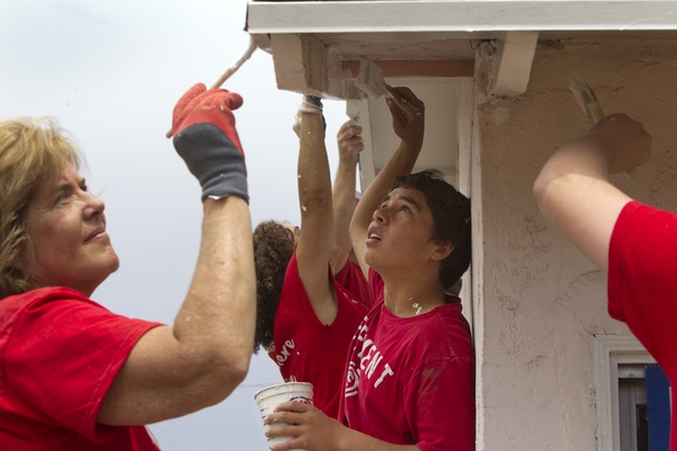 Adam Wahl, center, 14, a Foothills High School student, helps paint a home with Keller Williams associates from the Market Place Offices near Boulder Highway and Sahara Avenue Thursday, May 9, 2013. Wahl's parents work at the office, he said. The associates were among more than 70,000 workers around the world participating in the fifth annual Keller Williams RED Day. RED Day (Renew, Energize and Donate) is an initiative where Keller Williams associates donate a day to give back to the community.