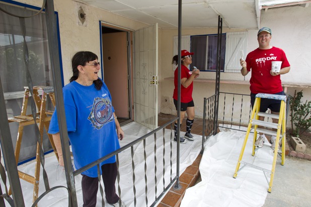 Homeowner Brenda Cox watches as Keller Williams associates from the Market Place Offices work on her home near Boulder Highway and Sahara Avenue Thursday, May 9, 2013. Cox shares the home with her 82-year-old mother. Rick Brenkus, who co-owns two Keller Williams franchises in Las Vegas, paints at right.  The associates were among more than 70,000 workers around the world participating in the fifth annual Keller Williams RED (Renew, Energize and Donate) Day.