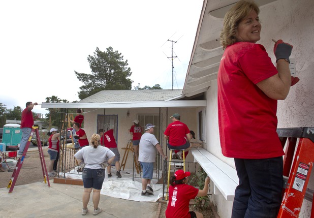Keller Williams associates from the Market Place Offices paint the exterior of a home near Boulder Highway and Sahara Avenue Thursday, May 9, 2013. The associates were among more than 70,000 workers around the world participating in the fifth annual Keller Williams RED Day. RED Day (Renew, Energize and Donate) is an initiative where Keller Williams associates donate a day to give back to the community.