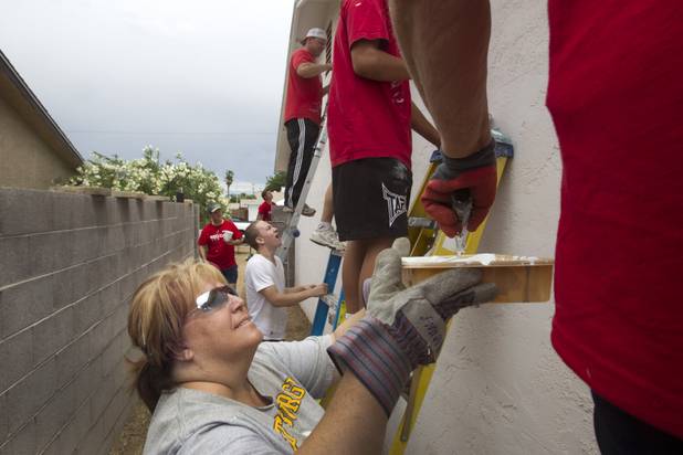 Pam Nichols holds a paint tray as Keller Williams associates from the Market Place Offices work on a home near Boulder Highway and Sahara Avenue Thursday, May 9, 2013. The associates were among more than 70,000 workers around the world participating in the fifth annual Keller Williams RED Day. RED Day (Renew, Energize and Donate) is an initiative where Keller Williams associates donate a day to give back to the community.