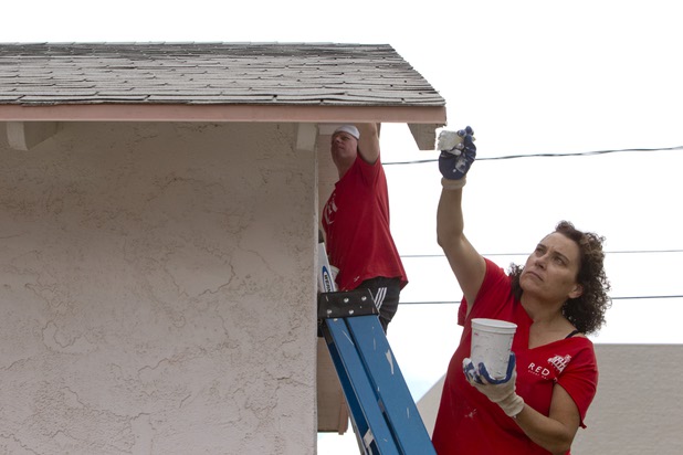 Teri Olson, a Keller Williams Market Place Offices receptionist, paints the exterior of a home near Boulder Highway and Sahara Avenue Thursday, May 9, 2013. The Keller Williams associates were among more than 70,000 workers around the world participating in the fifth annual RED Day. RED Day (Renew, Energize and Donate) is an initiative where Keller Williams associates donate a day to give back to the community.