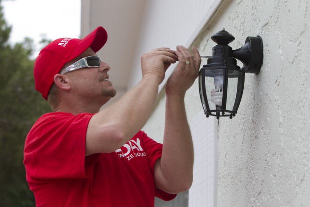 Michael Klinger installs new exterior lighting as Keller Williams associates from the Market Place Offices work on a home near Boulder Highway and Sahara Avenue Thursday, May 9, 2013. The associates were among more than 70,000 workers around the world participating in the fifth annual Keller Williams RED Day. RED Day (Renew, Energize and Donate) is an initiative where Keller Williams associates donate a day to give back to the community.