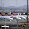 In this Thursday, May 9, 2013, photo, a Southwest airliner comes in for a landing as a row of Allegiant Air jets are parked at McCarran International Airport in Las Vegas.