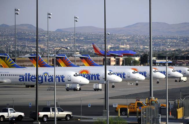 In this Thursday, May 9, 2013, photo, a Southwest airliner comes in for a landing as a row of Allegiant Air jets are parked at McCarran International Airport in Las Vegas.