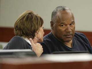O.J. Simpson, right, talks with his attorney, Patricia Palm in Clark County District Court, Monday, May 13, 2013, in Las Vegas. Simpson, who is currently serving a nine to 33-year sentence in state prison for his October 2008 conviction for armed robbery and kidnapping, is using a writ of habeas corpus, to seek a new trial, claiming he had such bad representation that his conviction should be reversed. 