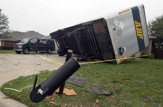 A semi trailer sits on its side, Thursday, May 16, 2013, after it was knocked onto homes after a tornado destroyed part of Cleburne, Texas late Wednesday.  