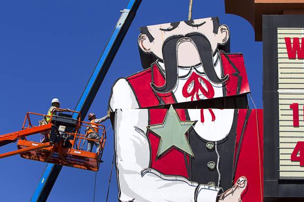 Workers take down the Terribles Cowboy signage at Terribles Hotel & Casino, 4100 Paradise Rd., Monday, May 20, 2013. The property is being renamed Silver Sevens Hotel & Casino. The new name and signage is part of a $5 million renovation project by Affinity Gaming. The cowboy sign is being donated to the Neon Museum.