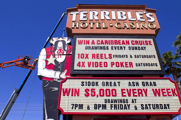Workers take down the Terribles Cowboy signage at Terribles Hotel & Casino, 4100 Paradise Rd., Monday, May 20, 2013. The property is being renamed Silver Sevens Hotel & Casino. The new name and signage is part of a $5 million renovation project by Affinity Gaming. The cowboy sign is being donated to the Neon Museum.