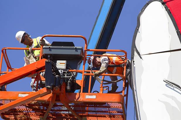 A workers crawls out of the Terribles Cowboy signage at Terribles Hotel & Casino, 4100 Paradise Rd., Monday, May 20, 2013. The property is being renamed Silver Sevens Hotel & Casino. The new name and signage is part of a $5 million renovation project by Affinity Gaming. The cowboy sign is being donated to the Neon Museum.