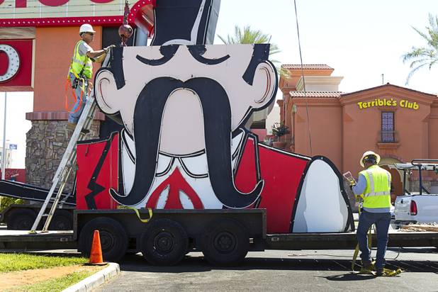 Workers secure the head of the Terribles Cowboy signage onto a flatbed trailer at Terribles Hotel & Casino, 4100 Paradise Rd., Monday, May 20, 2013. The property is being renamed Silver Sevens Hotel & Casino. The new name and signage is part of a $5 million renovation project by Affinity Gaming. The cowboy sign is being donated to the Neon Museum.