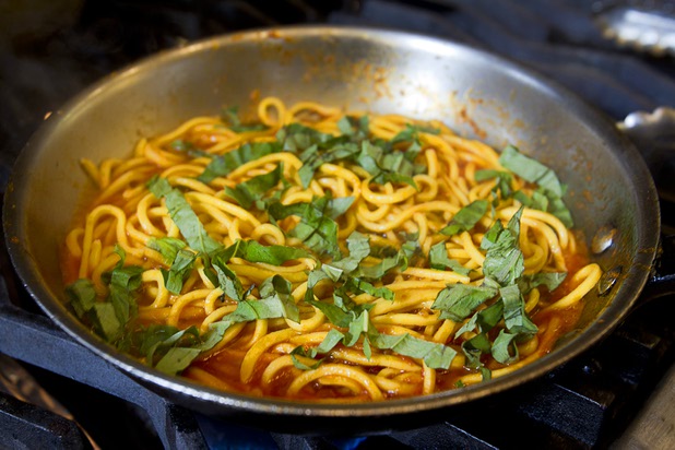 Basil is added to chef Scott Conant's spaghetti in the Scarpetta restaurant kitchen at the Cosmopolitan Wednesday, May 22, 2013.