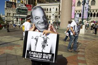 Leo Murieta, left, and Justin McAffee wear Carlos Slim masks as they protest against Slim, a Mexican businessman listed as the second richest man in the world by Bloomberg's Billionaire Index, in front of the Venetian Wednesday, May 22, 2013. Two Countries One Voice accuses Slim's telecommunication companies of engaging in predatory and monopolistic practices. The protest coincides with CTIA, a wireless technology convention, being held at the Sands Expo Center.