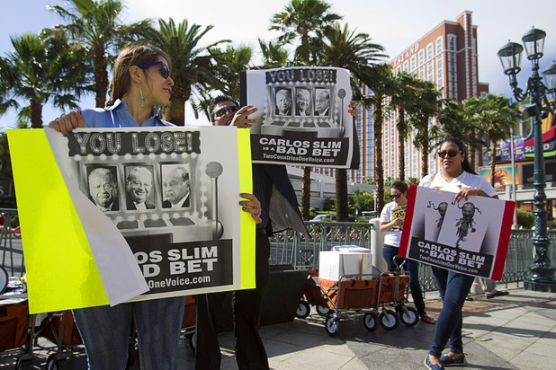 Jessica Padron, left, and members of Two Countries One Voice protest against Carlos Slim, a Mexican businessman listed as the second richest man in the world by Bloomberg's Billionaire Index, in front of the Venetian Wednesday, May 22, 2013. The group accuses Slim's telecommunication companies of engaging in predatory and monopolistic practices. The protest coincides with CTIA, a wireless technology convention, being held at the Sands Expo Center.