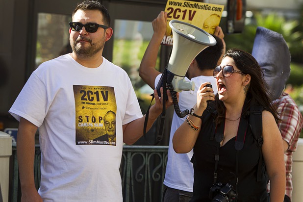 Rosalyn Jimenez, right, leads members of Two Countries One Voice in a chant as they protest against Carlos Slim, a Mexican businessman listed as the second richest man in the world by Bloomberg's Billionaire Index, in front of the Venetian Wednesday, May 22, 2013. The group accuses Slim's telecommunication companies of engaging in predatory and monopolistic practices. The protest coincides with CTIA, a wireless technology convention, being held at the Sands Expo Center.